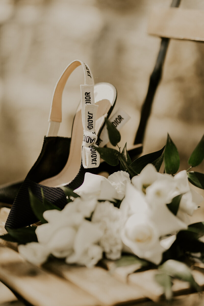 Escarpins noir Dior j'adore avec bouquet de roses blanches, pris par Laura, photographe professionnelle lors d'un mariage en vendée.