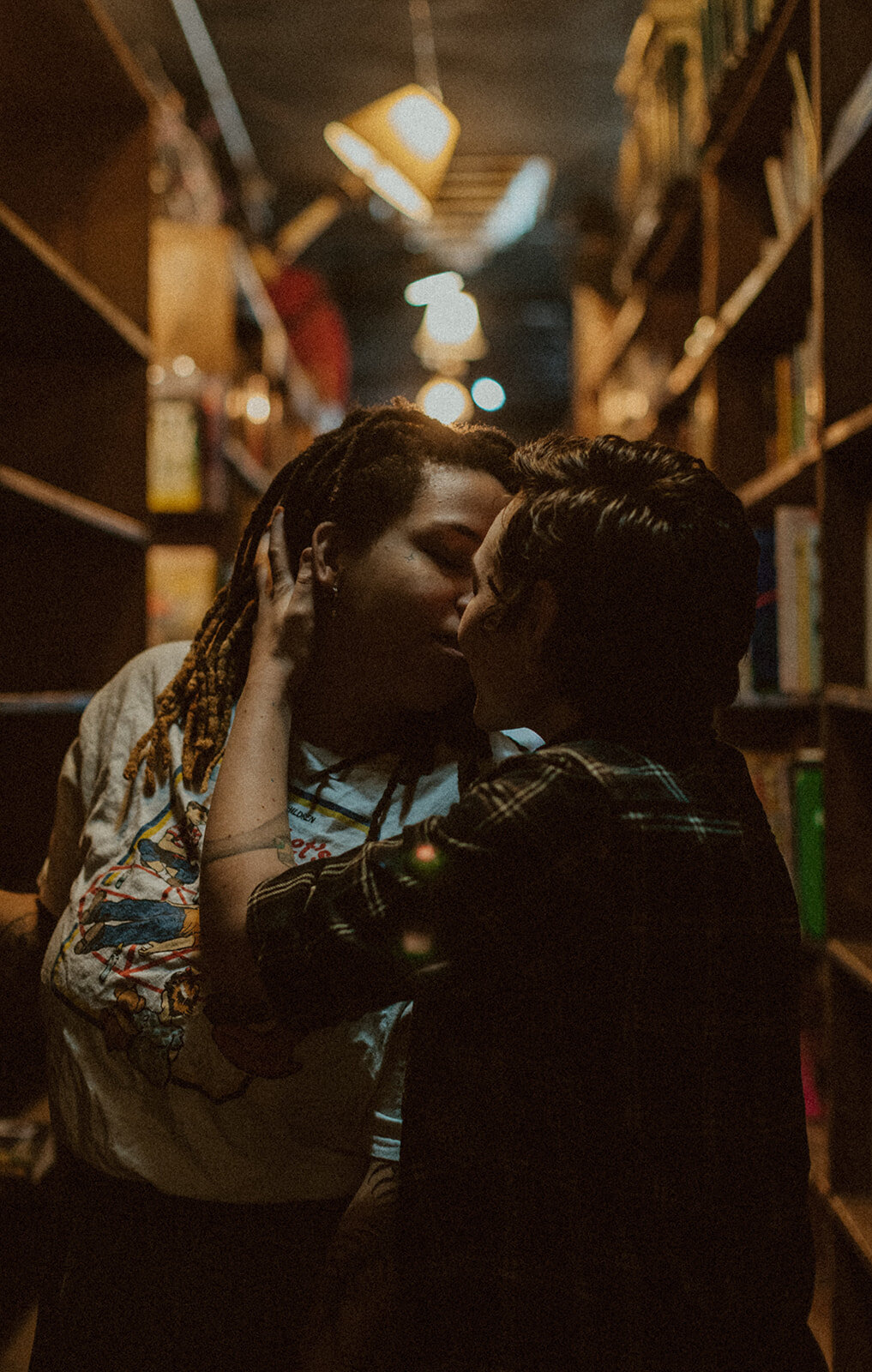 lgbtq couple kisses in a library 