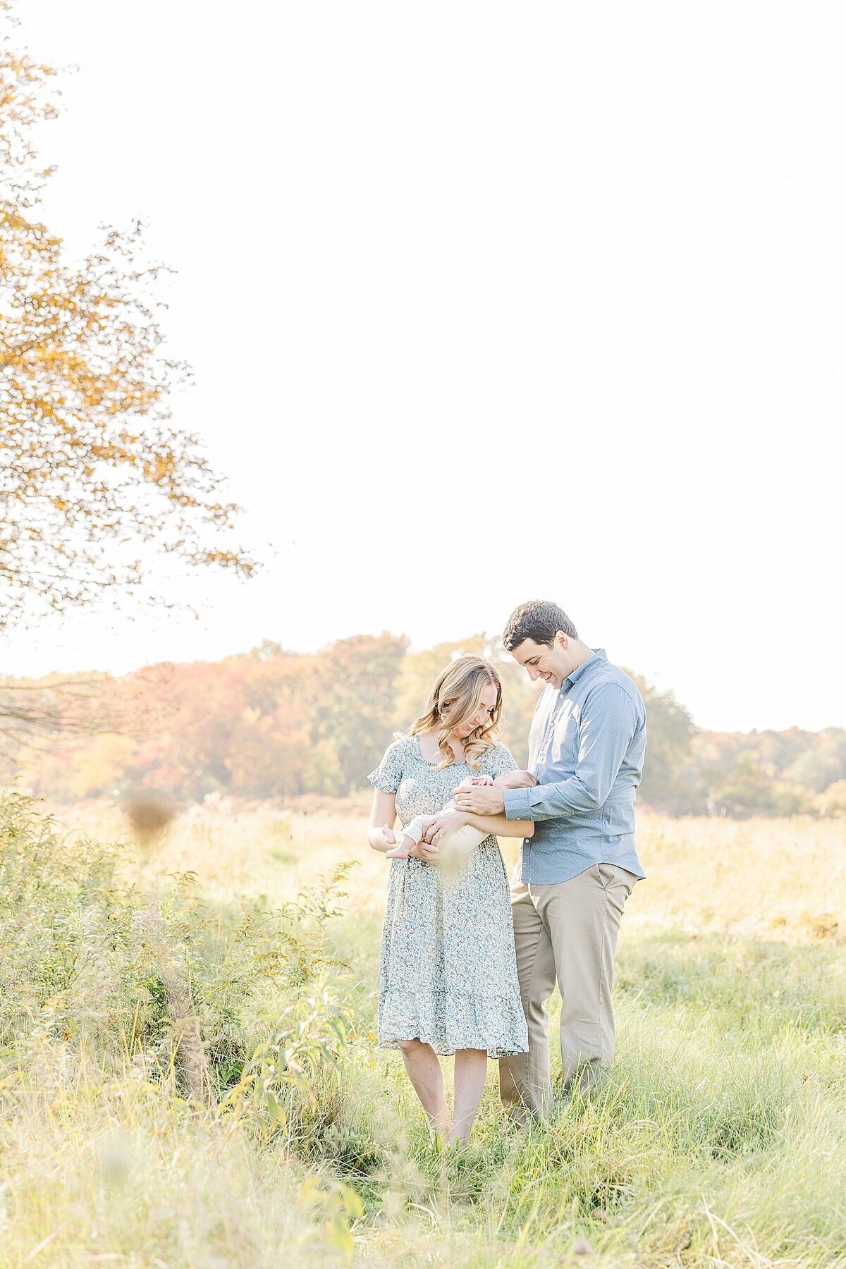 parents hold baby during outdoor newborn photo session in Natick Massachusetts with Sara Sniderman Photography