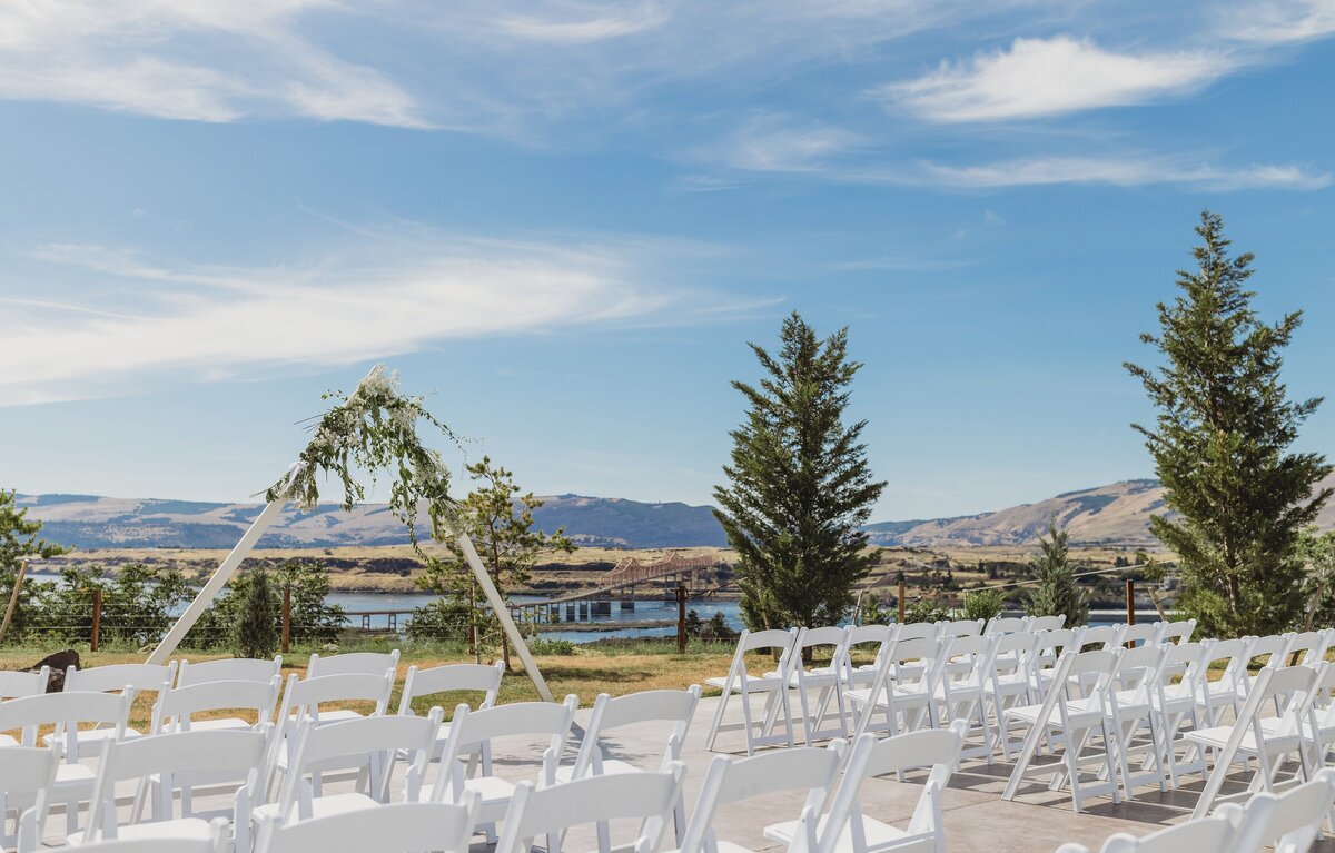 Columbia River Gorge Wedding venue & hotel with tent and string lights at night, and motel and mountain in the background