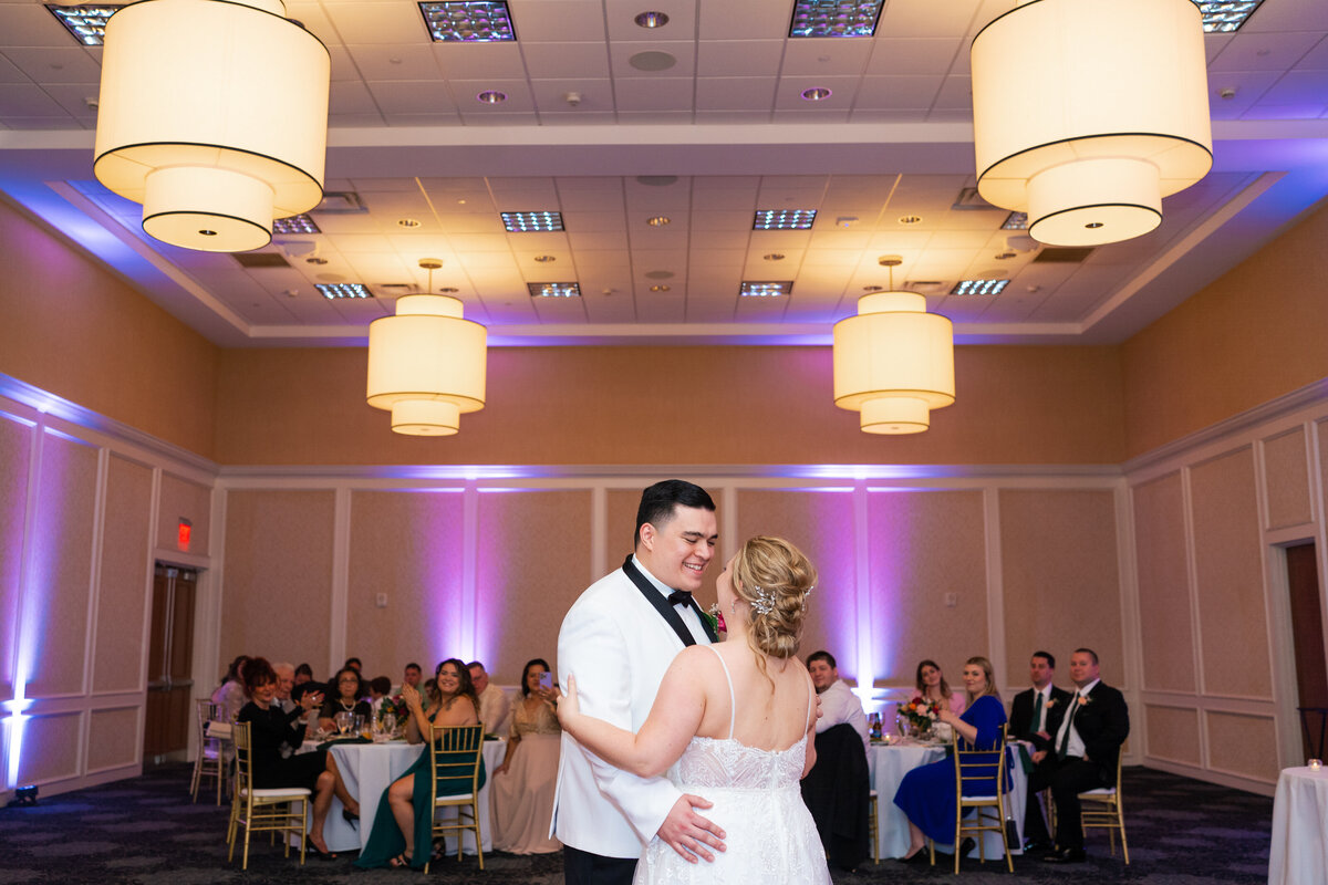 Bride and groom share their first dance with chandeliers framing them and their guests watching at Nationwide Hotel and Conference Center in Lewis Center, Ohio.