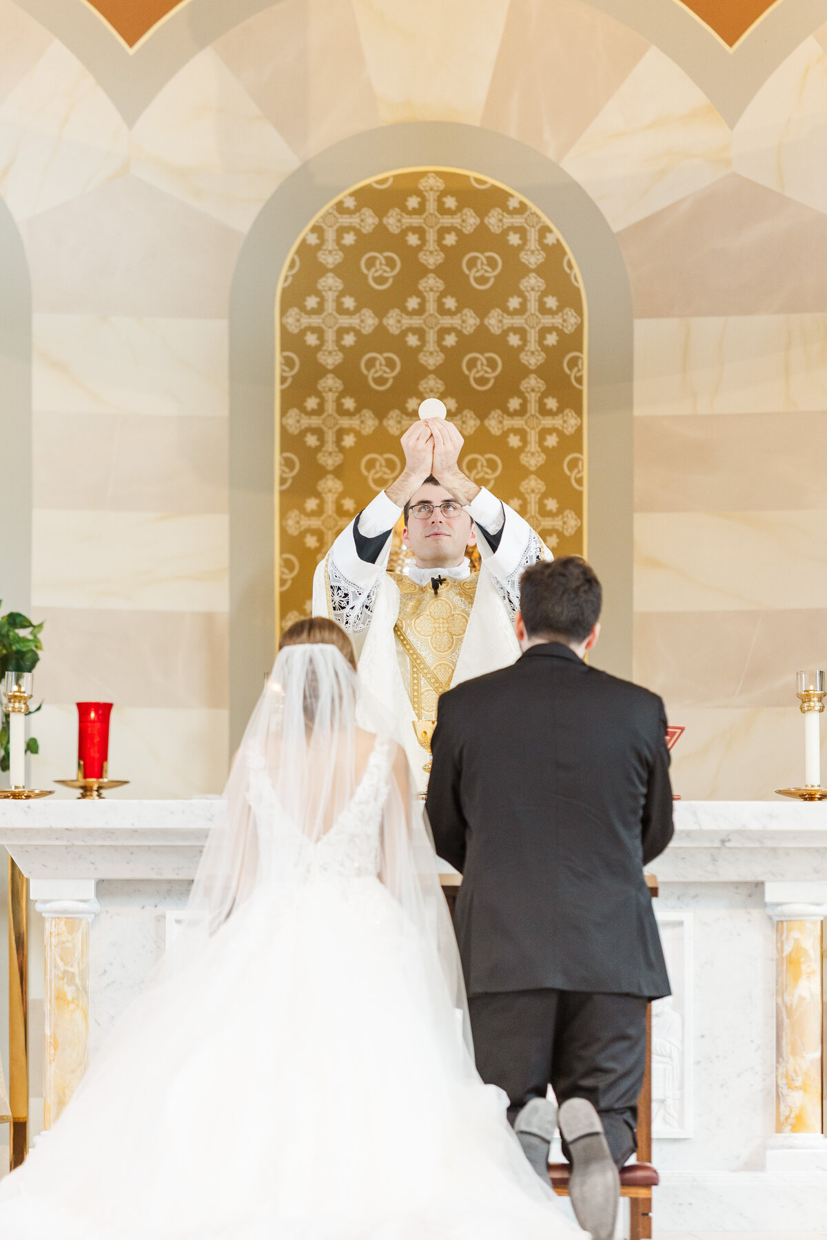 bride and groom participating in a Catholic wedding ceremony at a church