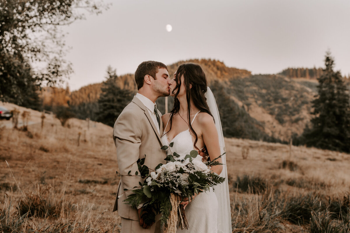 couple kissing with moon above