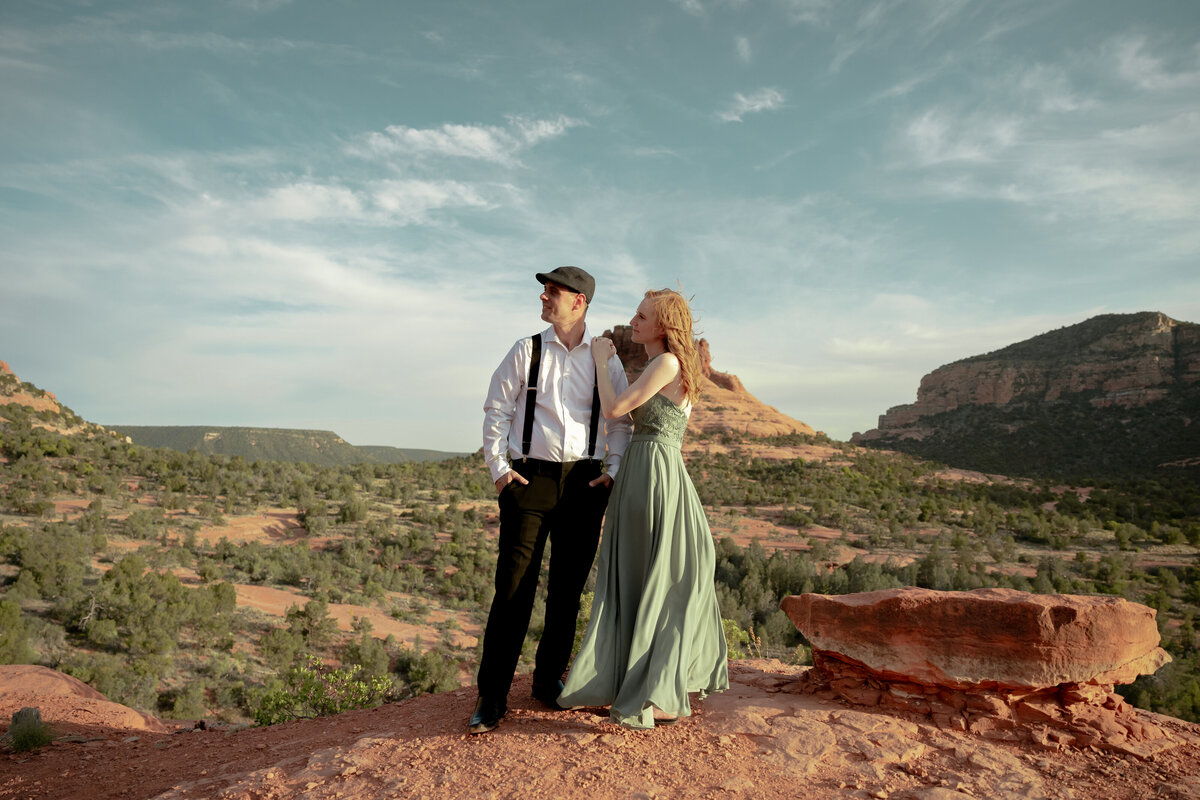 Couple standing against red rock backdrop during Sedona engagement session