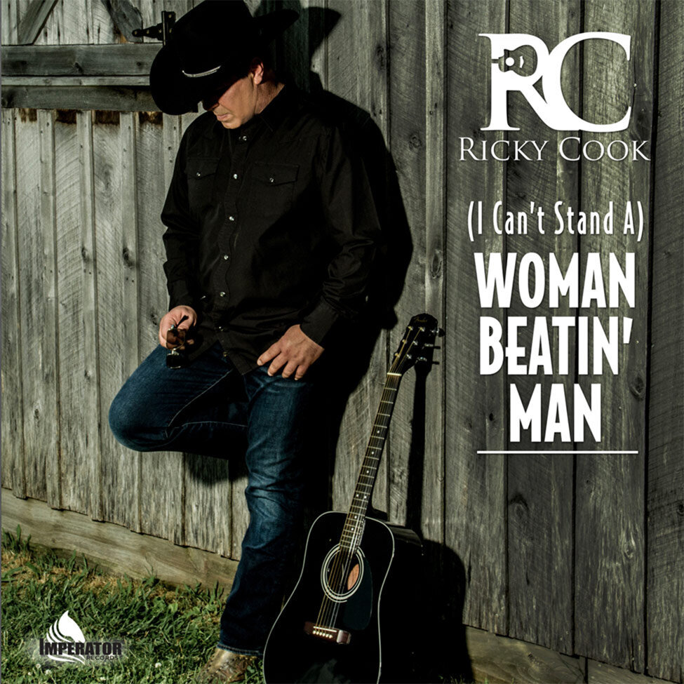 Single Cover Country Artist Ricky Cook Title Woman Beatin Man singer standing against grey wood barn looking down wearing black cowboy hat guitar leaning against wood wall beside him