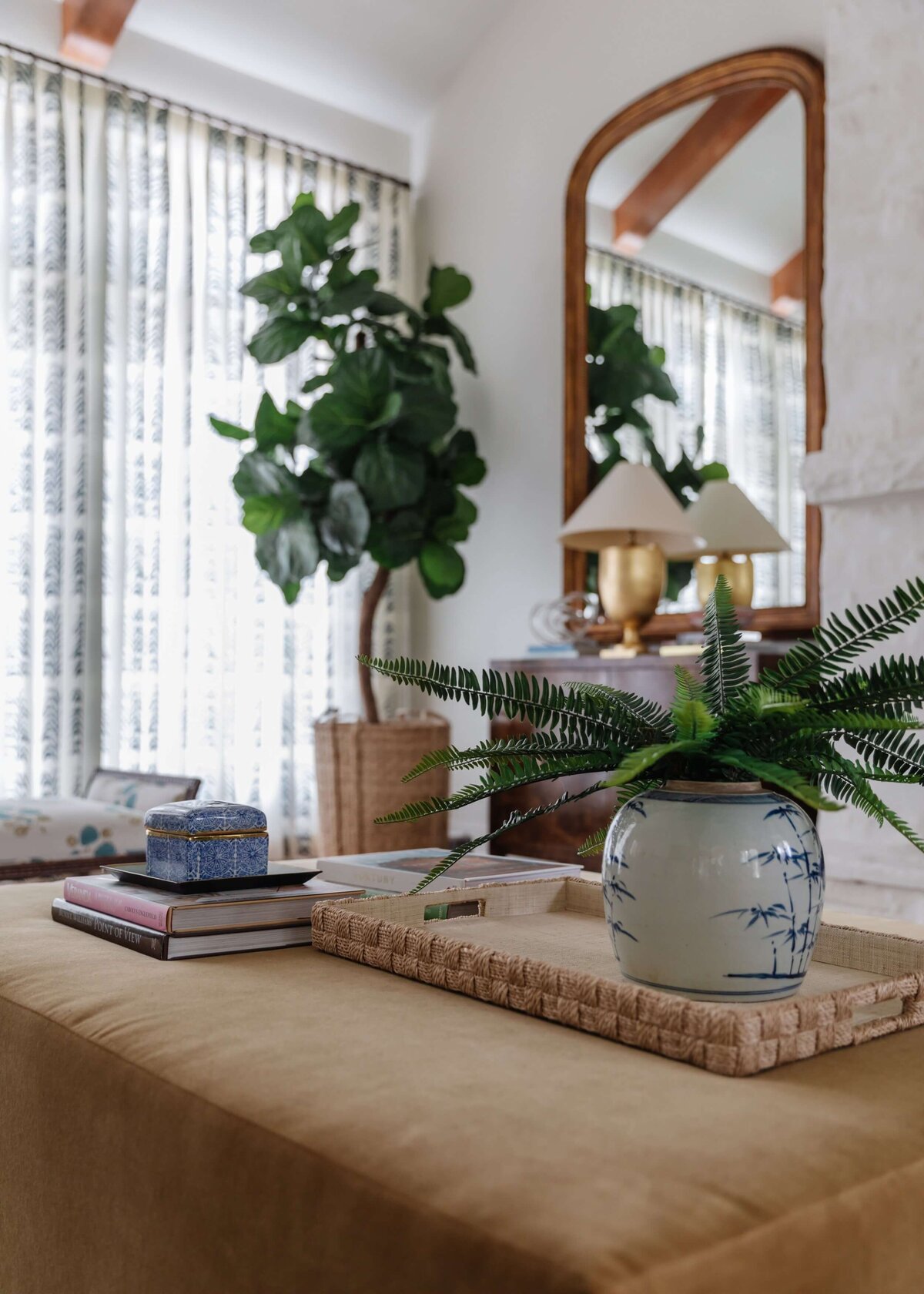 oyster creek studios home on the range plants and accent mirror with brown ottoman in living room