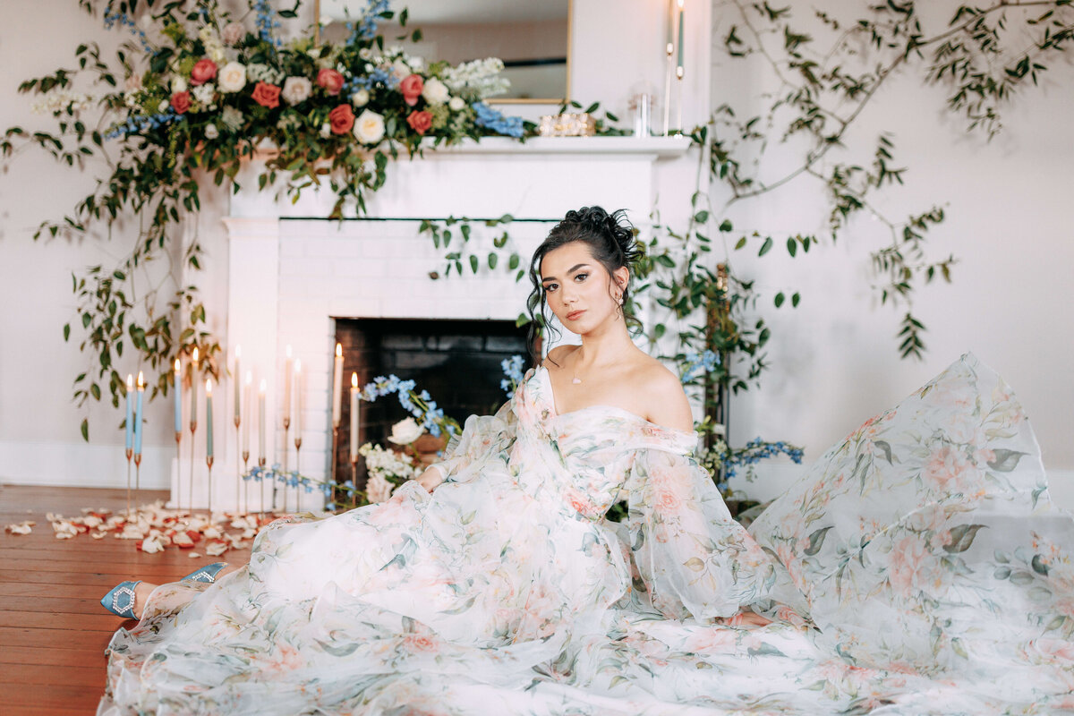 bride sitting on floor surrounded by florals