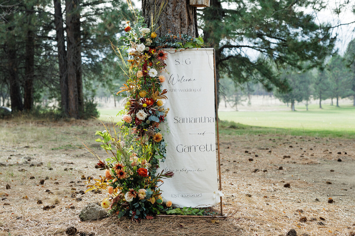 Welcome sign with fall wildflowers against pine tree at Pole Creek Ranch in Sisters Oregon