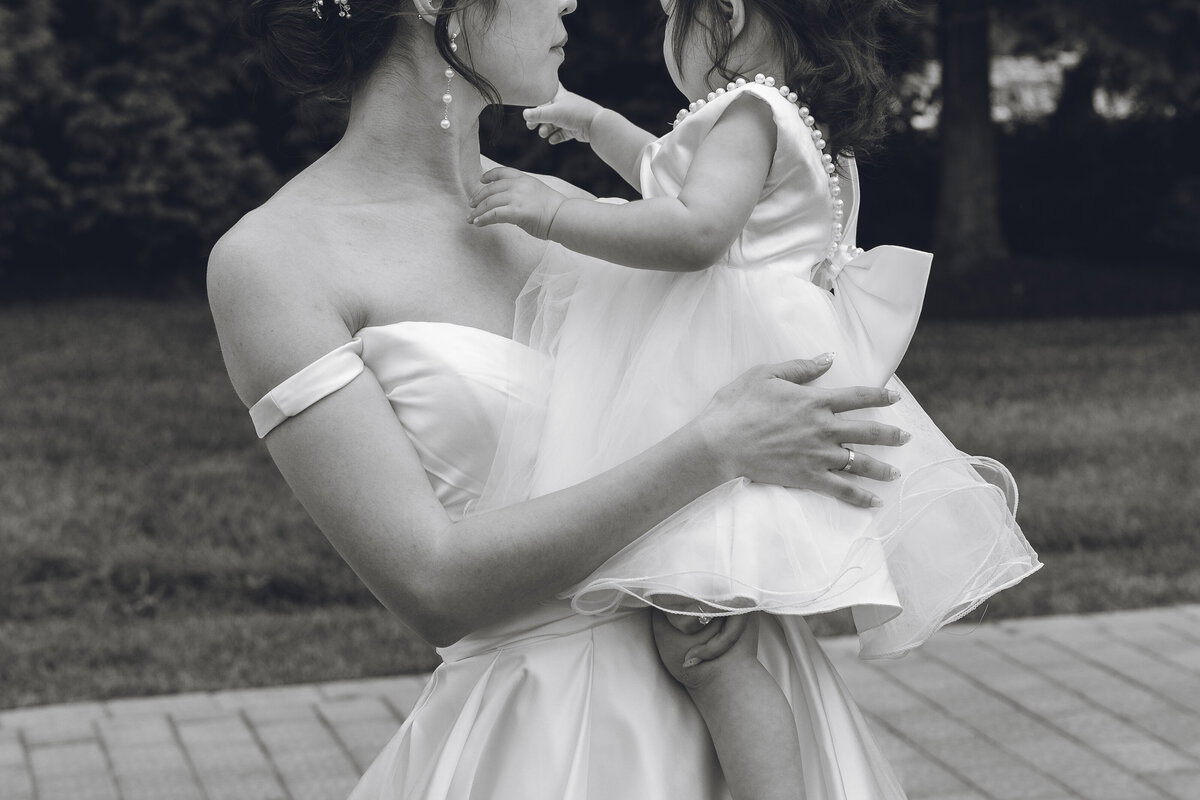 Bride and flower girl sharing a hug outside Crystal Springs Resort
