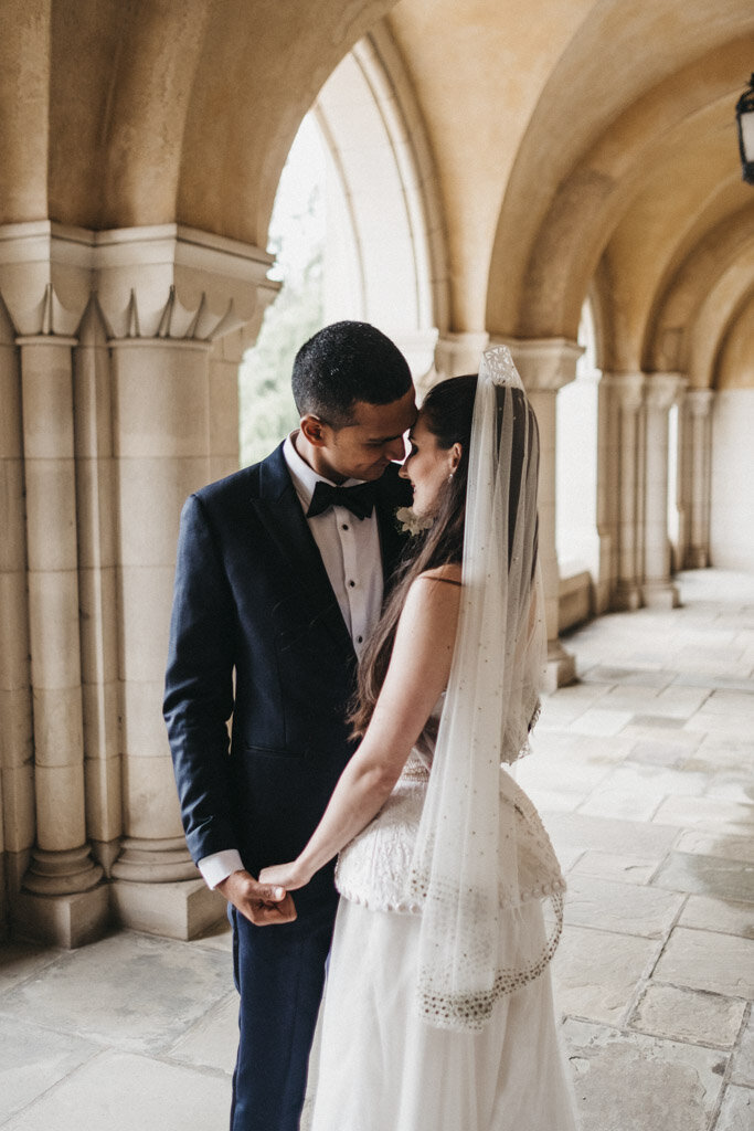 The romantic moment was captured at the stunning Mellon Auditorium in Washington D.C. Known for its European flair and luxurious ambiance, it served as the perfect backdrop for the newlywed couple's intimate embrace. Photographer Sarah Bradshaw skillfully encapsulated the love shared between the groom, clad in a sleek black suit and bow tie, and the bride, adorned in a white wedding dress with a delicate lace veil. As they held hands and gazed lovingly into each other's eyes under the elegant stone arches, their connection was beautifully immortalized in the photograph.