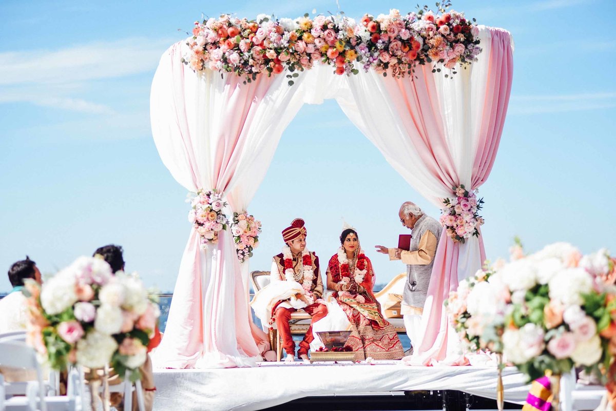 We created this stunning round mandap with peach and coral floral for this outdoor summer Indian ceremony at Hyatt Regency Lake Washington.