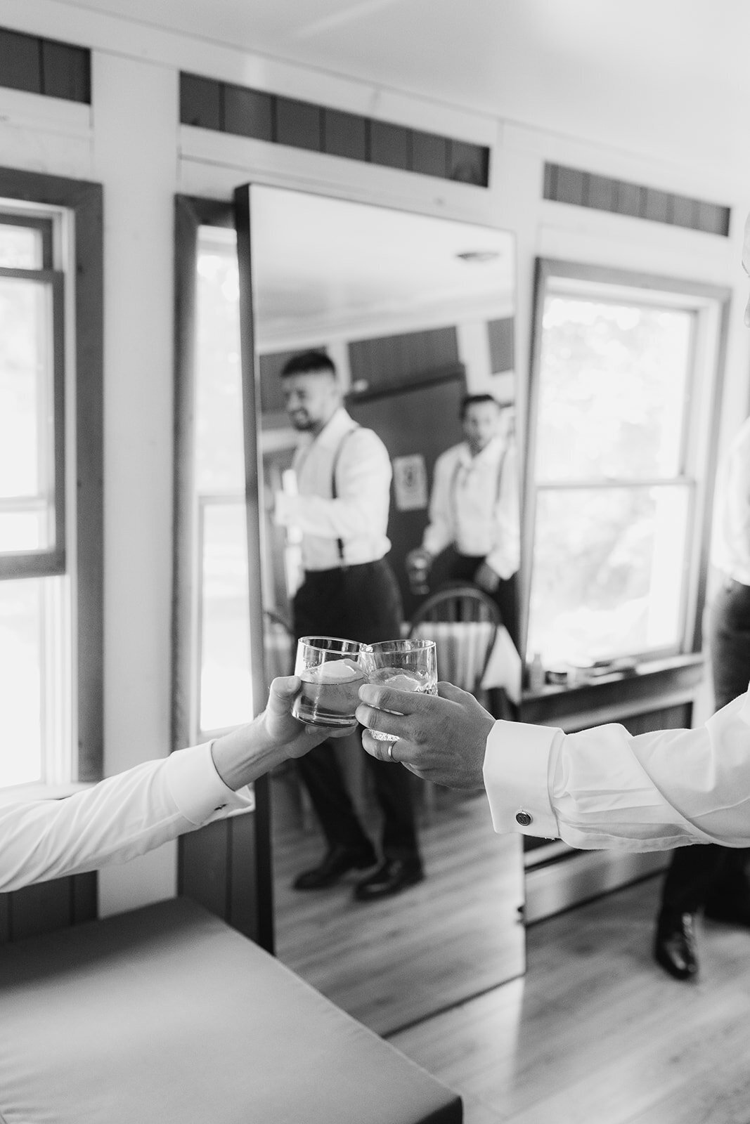 groom enjoys a drink with grooms men during wedding