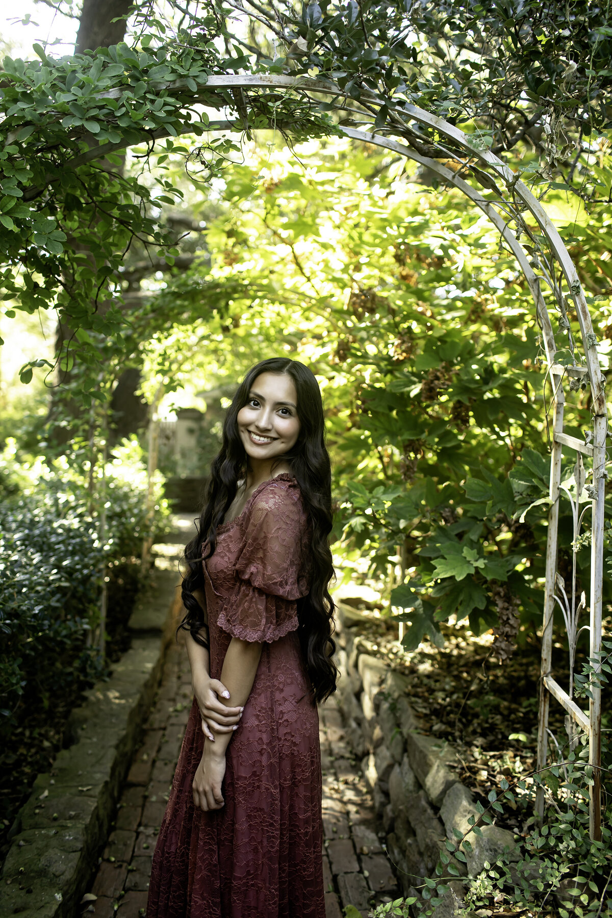 A high school senior posing by the iconic stone structures of Chandor Gardens, Weatherford, TX, showcasing their elegance and excitement for the future
