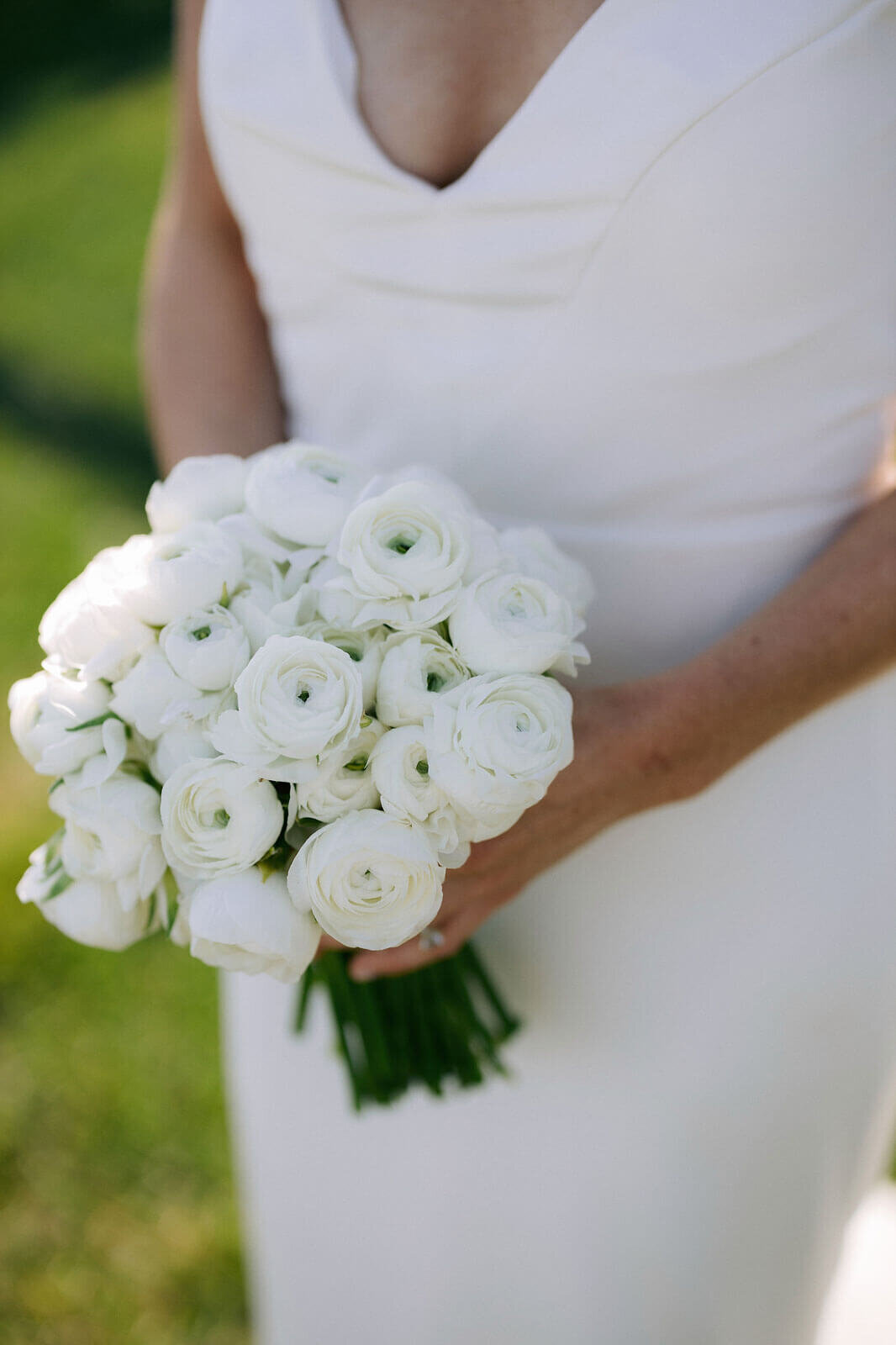 Close-up view of a bouquet of white flowers held by the bride outside Wianno Club, Cape Cod, MA.