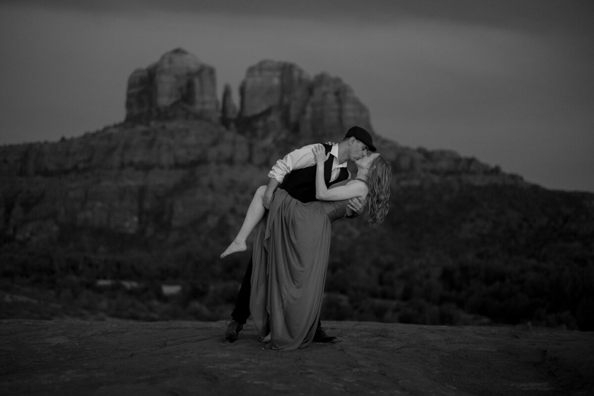 Couple standing against red rock backdrop during Sedona engagement session