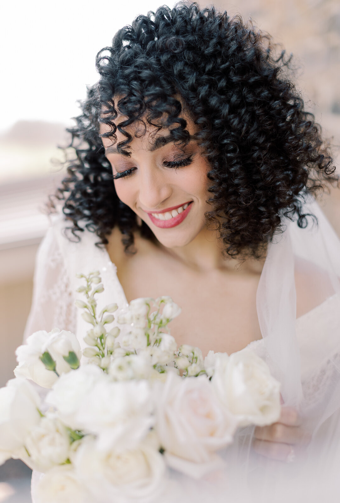 Bride with curly hair poses for bridal portraits