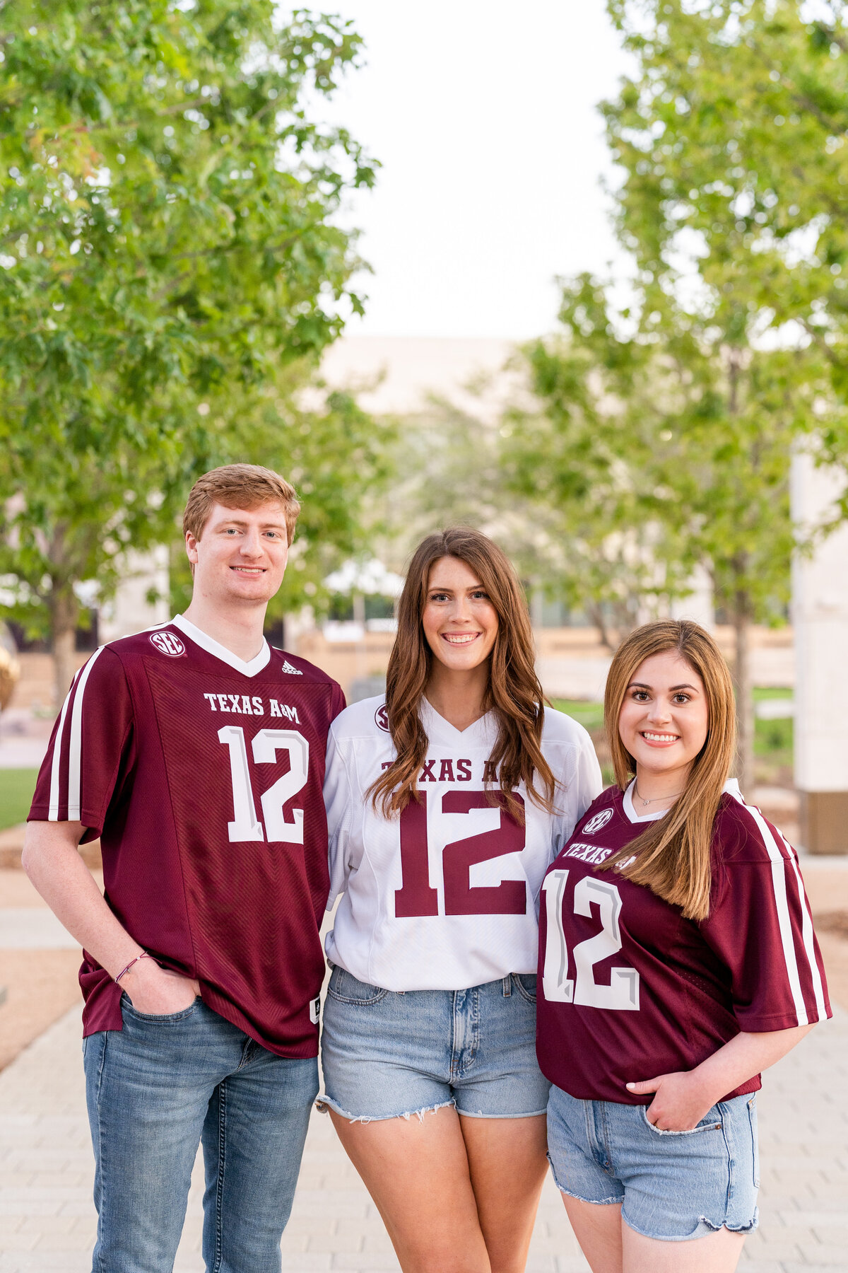Texas A&M senior friends with arms around each other while wearing A&M jerseys and smiling in Aggie Park