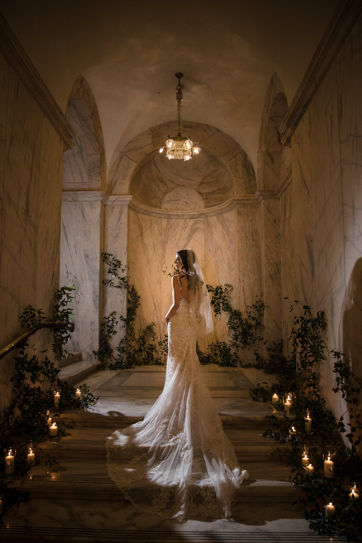 A bride walking up a small set of stairs as she looks back over her shoulder.