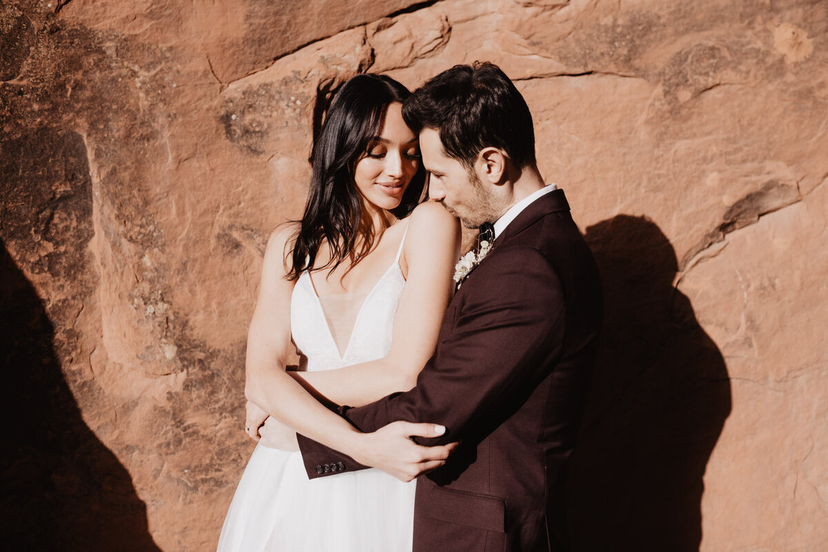 Utah elopement photographer captures groom kissing bride's shoulder