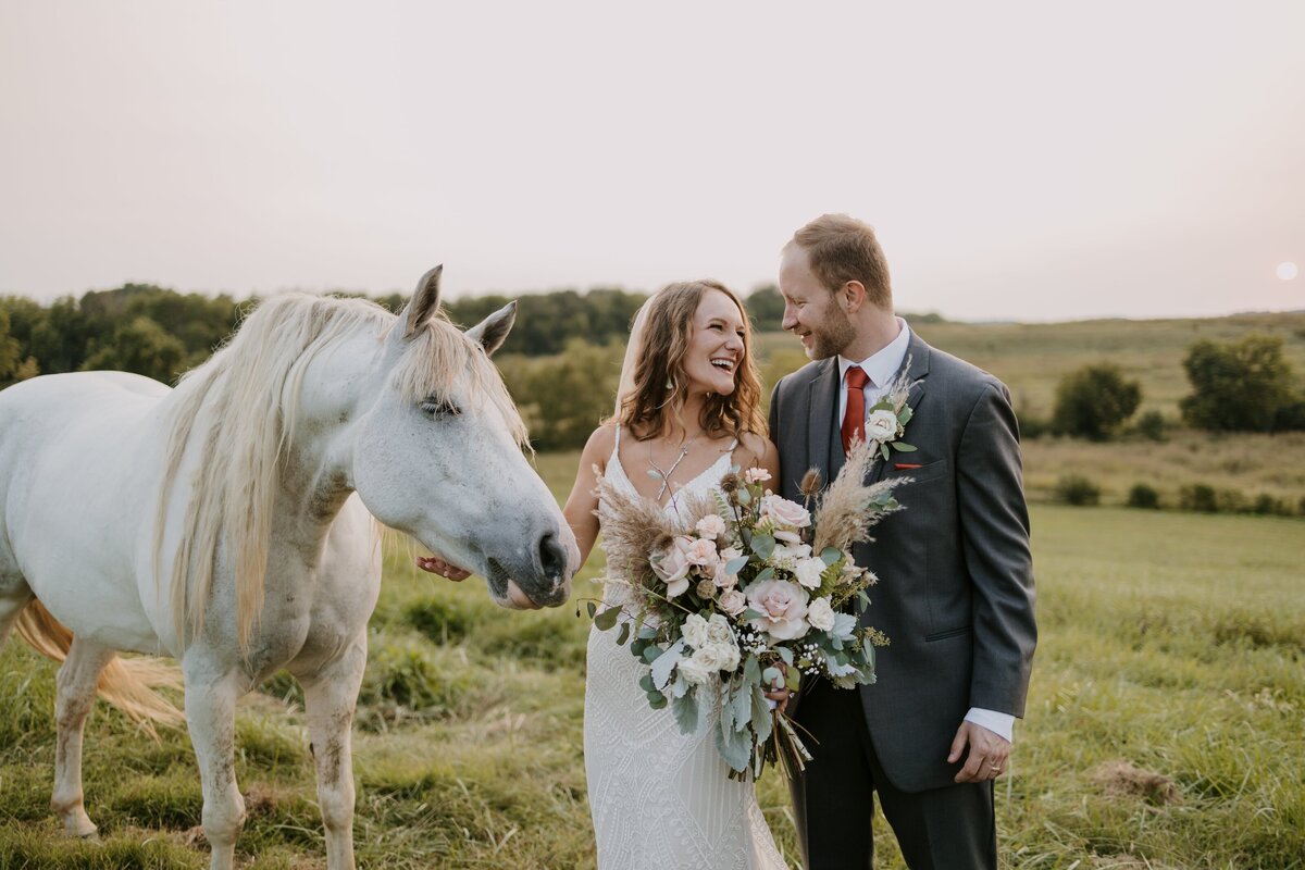 Bride and groom stand with horse at outdoor ceremony in Tennessee