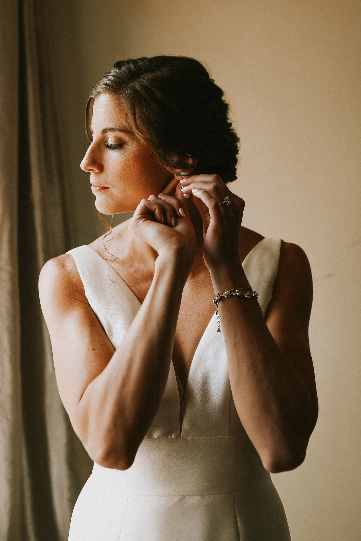 bride-getting-ready-putting-on-her-earrings-saint-clements-castle