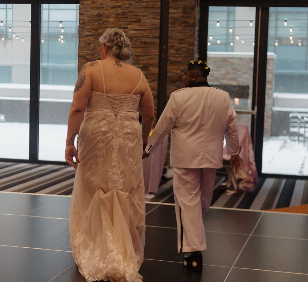 A wedding couple holding hands and walking together.