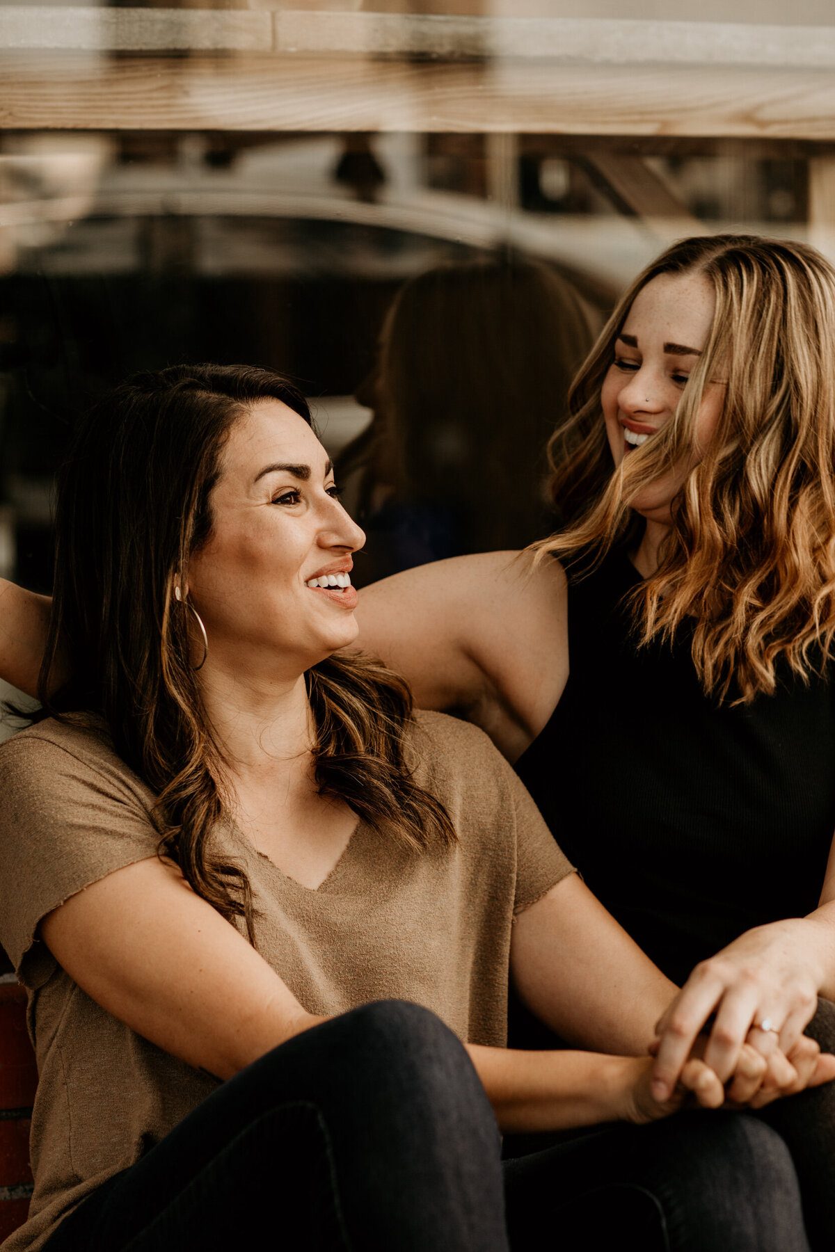 lesbian couple sitting together outside of a coffee shop