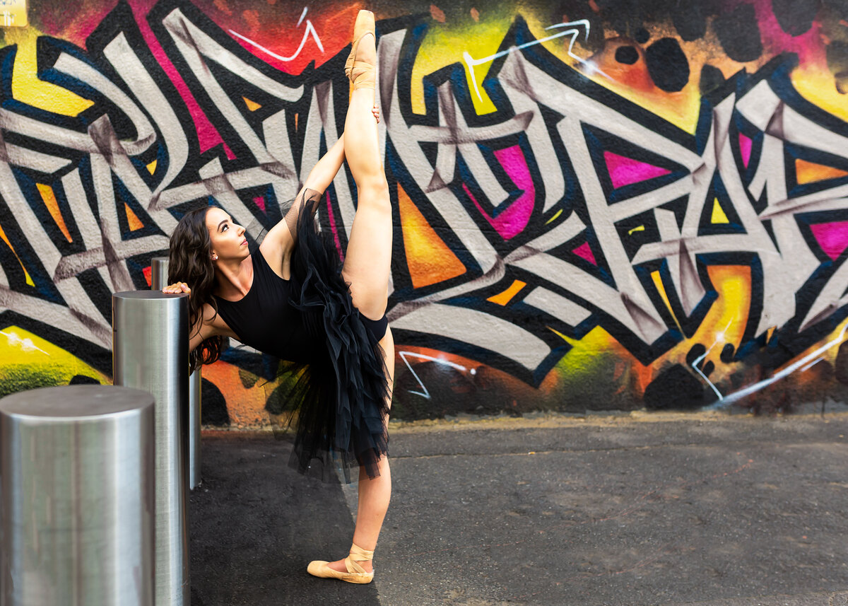 Dancer in tutu doing splits near Canberra graffiti wall