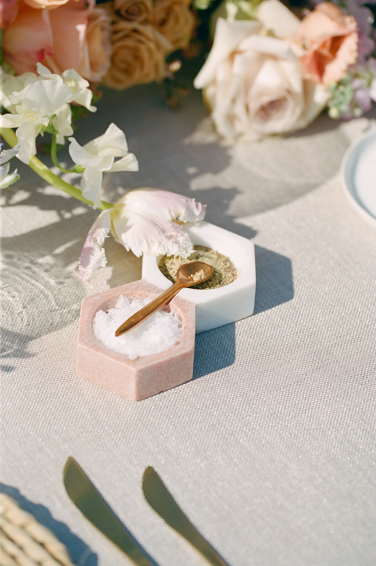 Some of the gorgeous flowers on a table with a mini spoon.