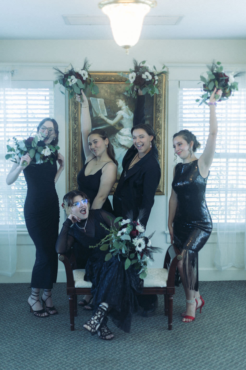 A wedding participant and their wedding party holding up bouquets of flowers.