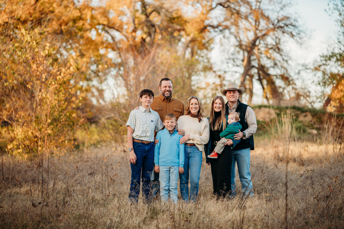 Family standing together under autumn trees — timeless Weatherford family photography by Poppy + Blue Photography