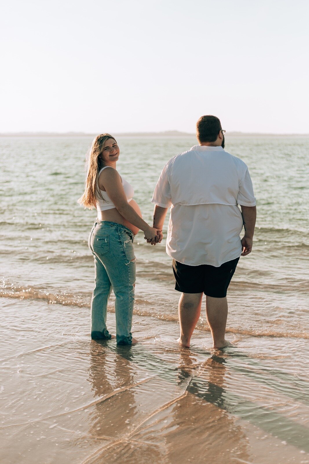 couple standing in the water on the beach