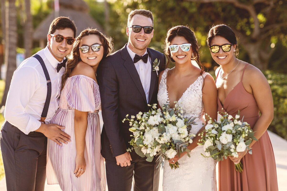 Groom, bride and bridal party wearing fun glasses at wedding at Secrets Maroma Riviera Maya