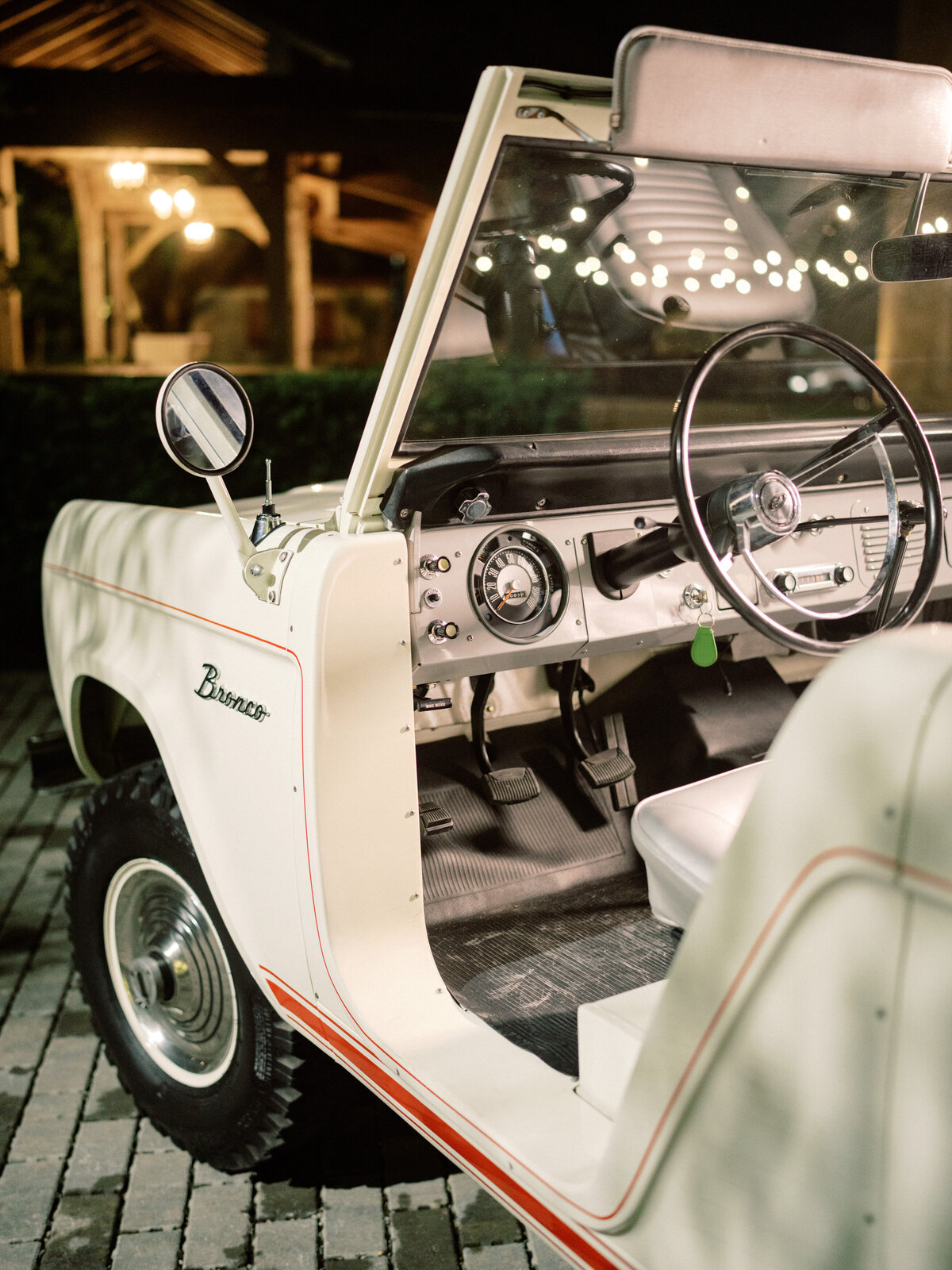 An inviting interior of a classic vintage Bronco displaying minimalistic design and nostalgic elements like chrome details, providing a glimpse of the retro automotive craftsmanship inside.