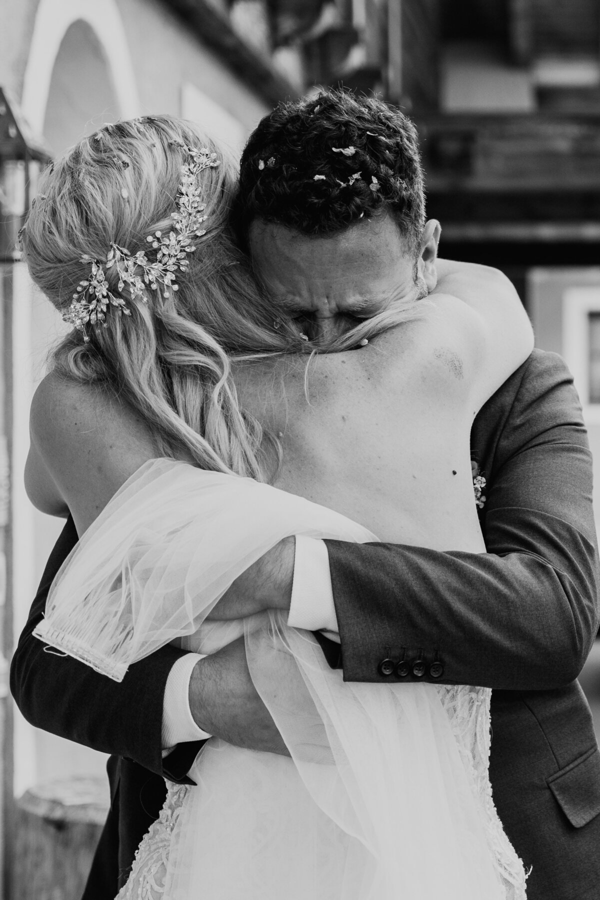 Bride and groom kissing outside rustic lodge Italy
