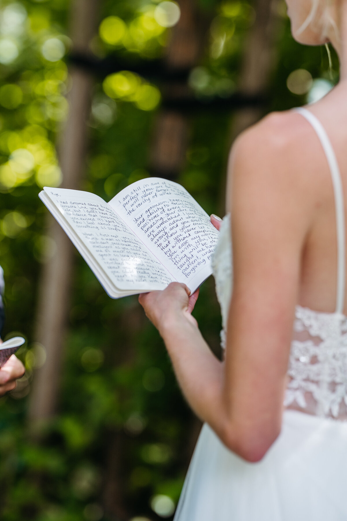 Close-up of bride holding vow book during ceremony