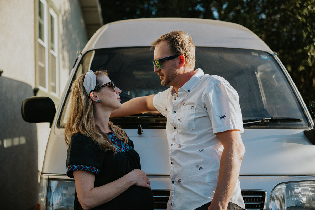 Couple leans on van looking at each other