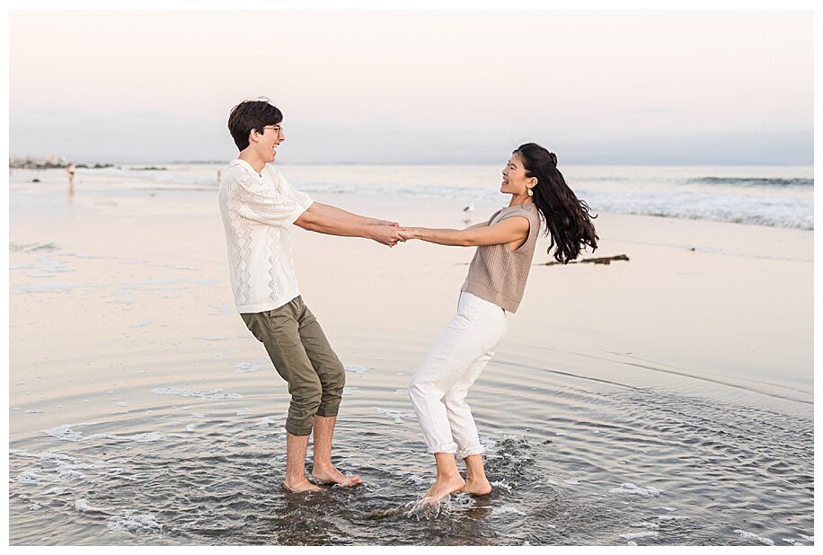engaged couple spinning in ocean at coronado beach san diego