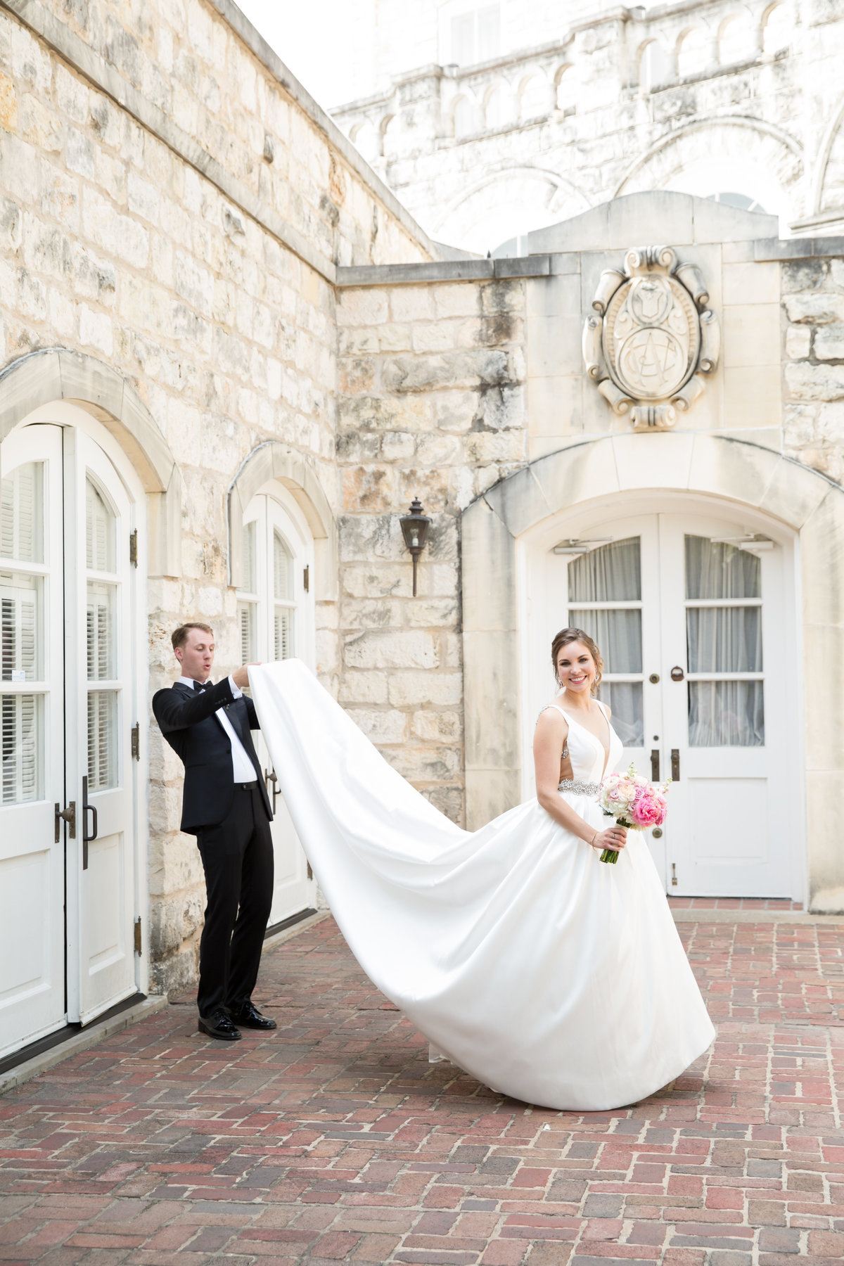 Austin wedding photographer chateau bellevue wedding photographer groom peeking under dress