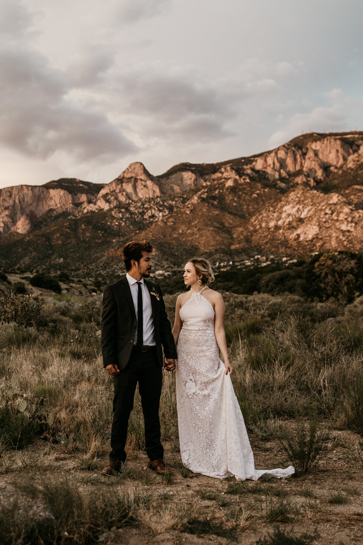 bride and groom holding hands in front of mountain