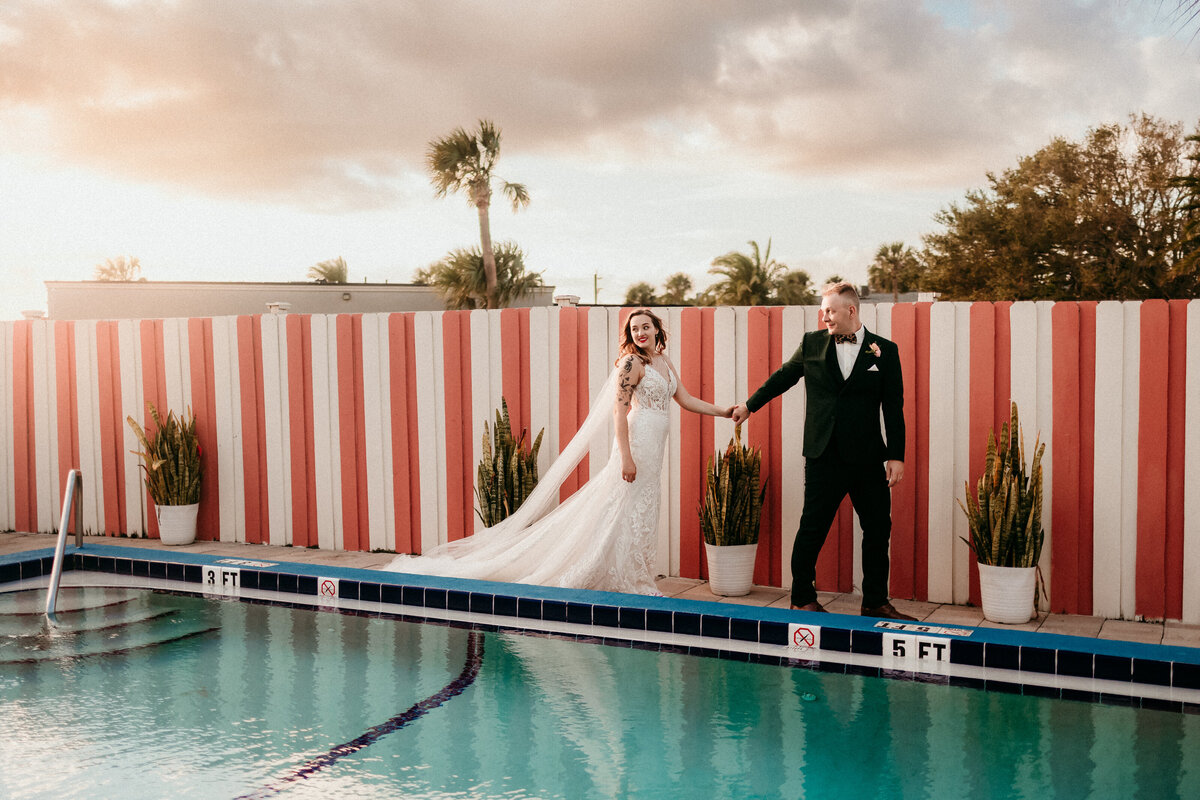 Bride and groom walking past a pool during their Jacksonville, Florida wedding.