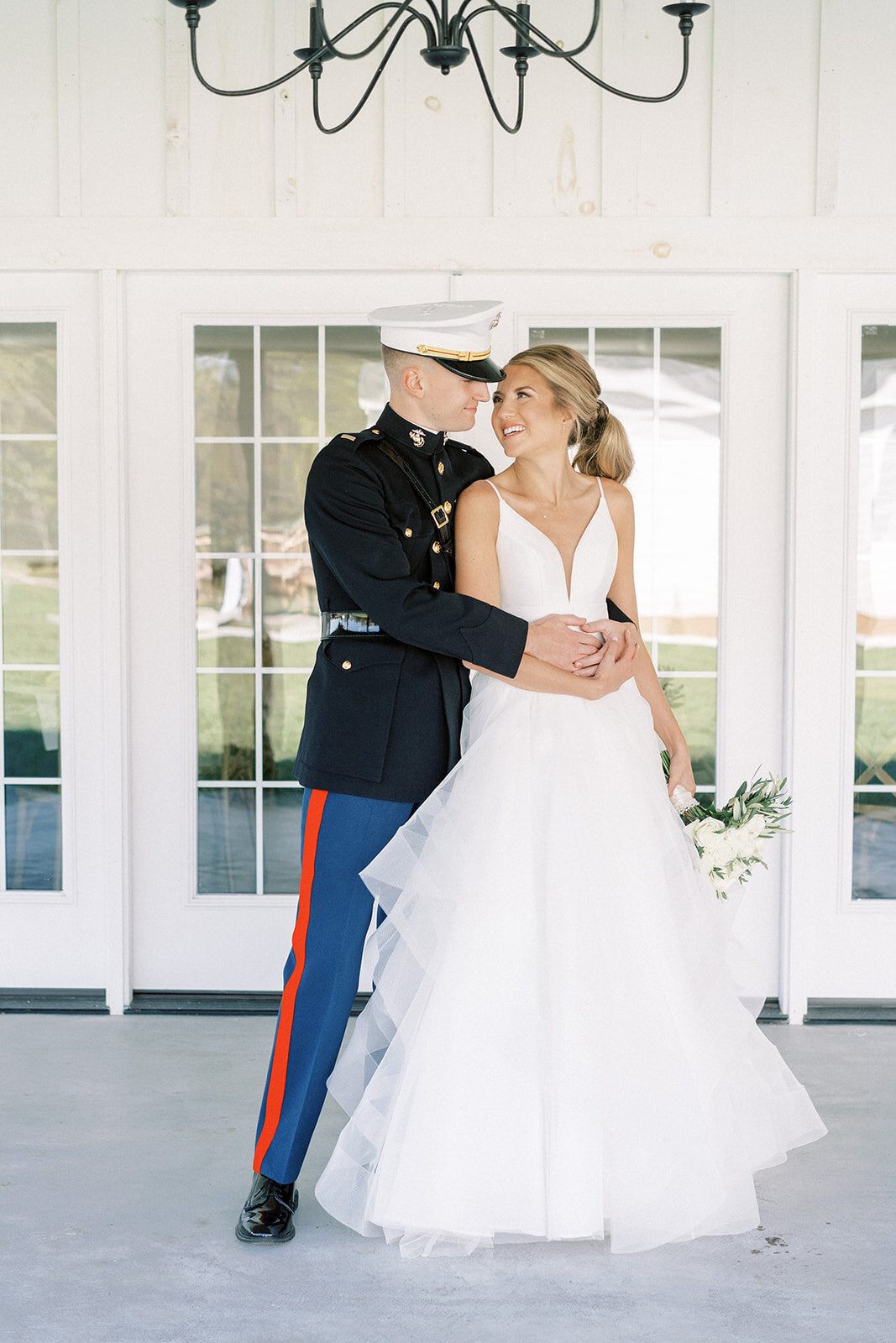 groom in a military uniform hugging a bride in her wedding dress