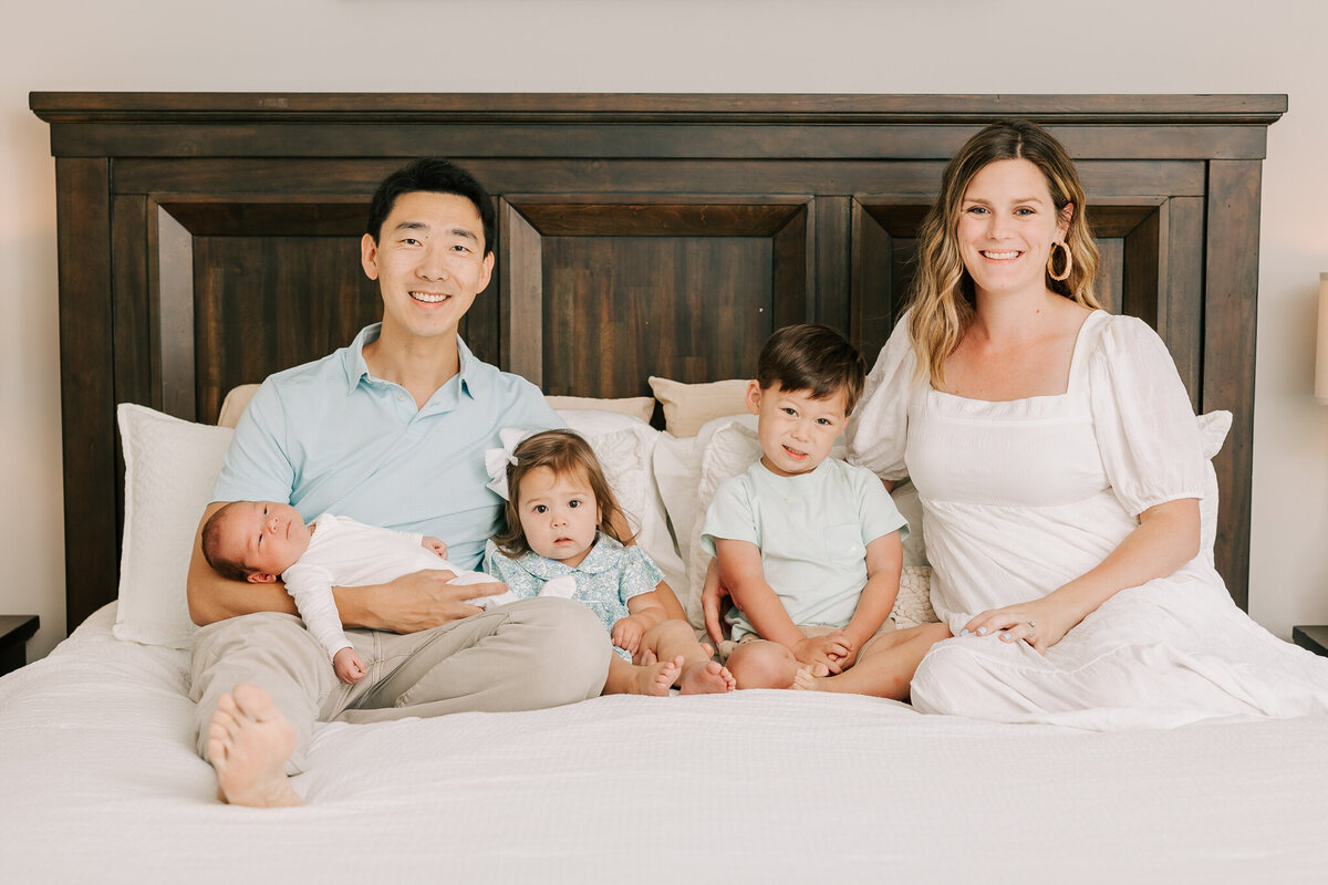Family of five smiling at the camera. Whole family is wearing clothing from the client closet of molly berry photography.
