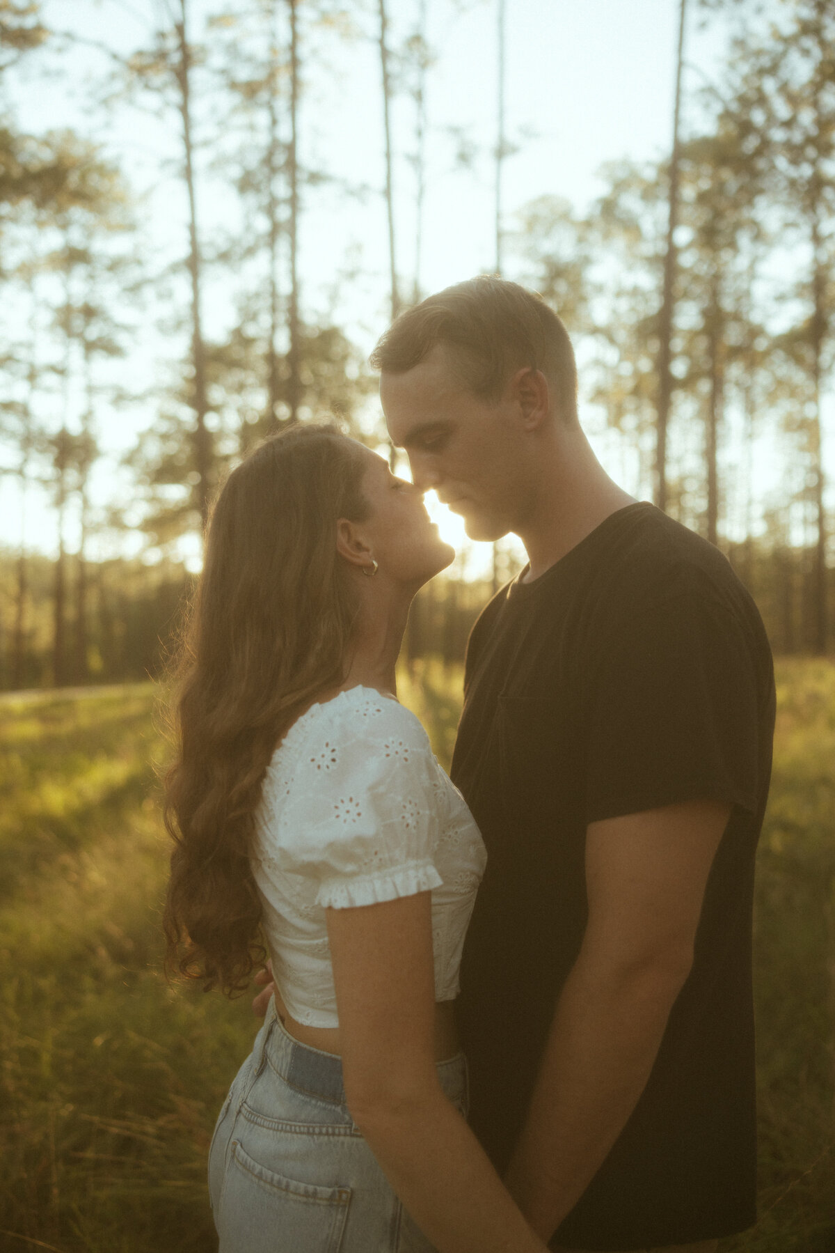 Couple posing for portraits in a forest.