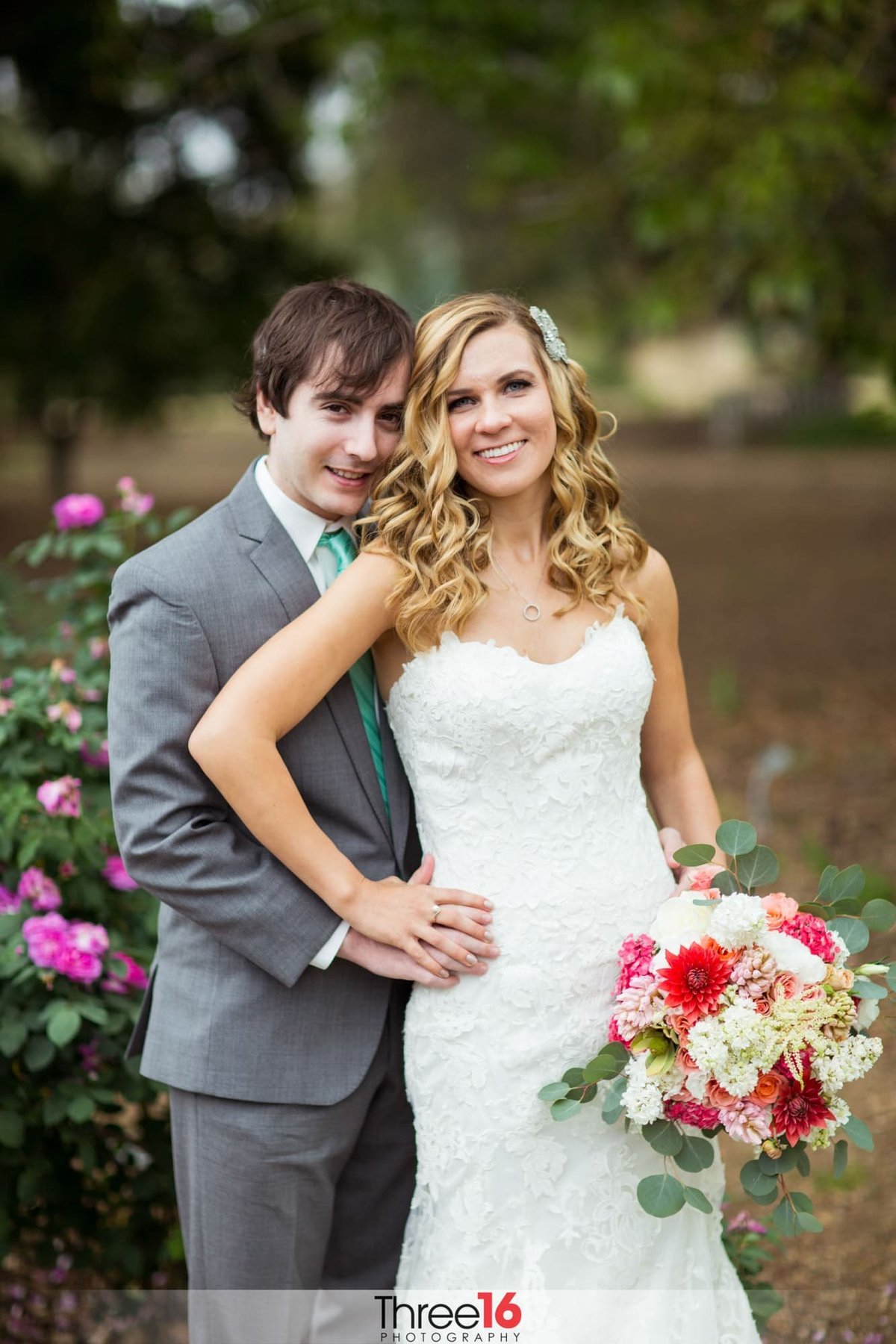 Bride and Groom pose for photos with his hand on her hip