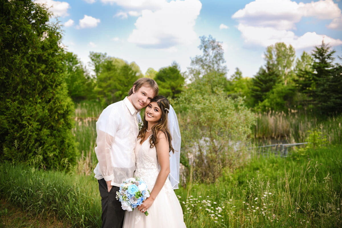 Bride and groom posing near serene pond