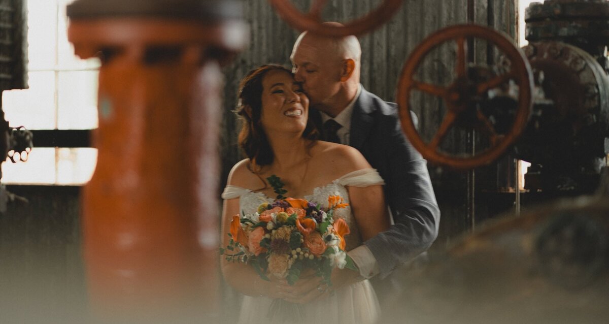 Wedding couple hold each other in historic gas plant near Calgary, Alberta