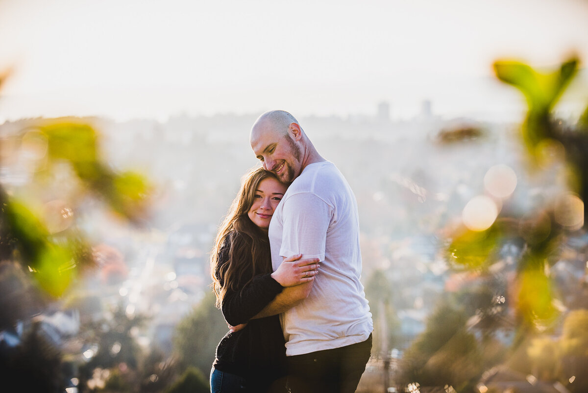 Couple hugging on hill overlooking downtown Victoria