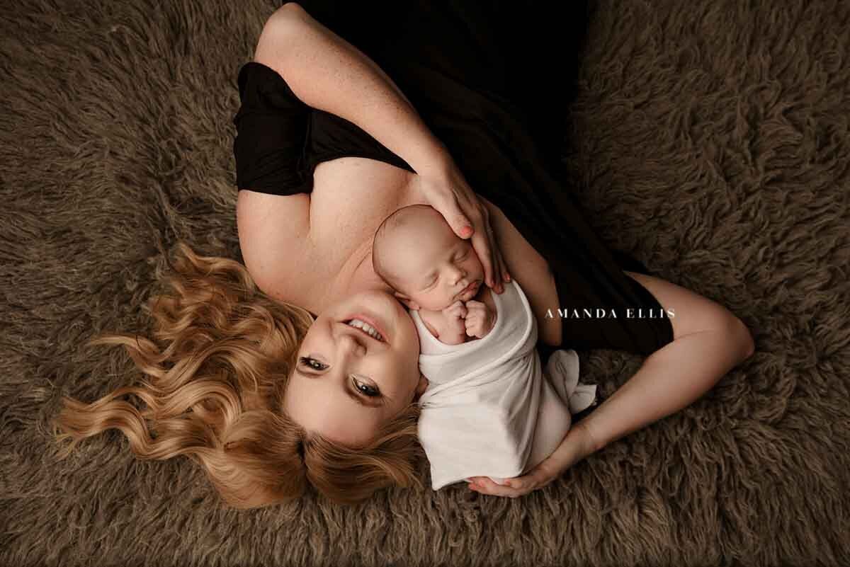 Portrait of woman and baby posed for newborn photography shoot