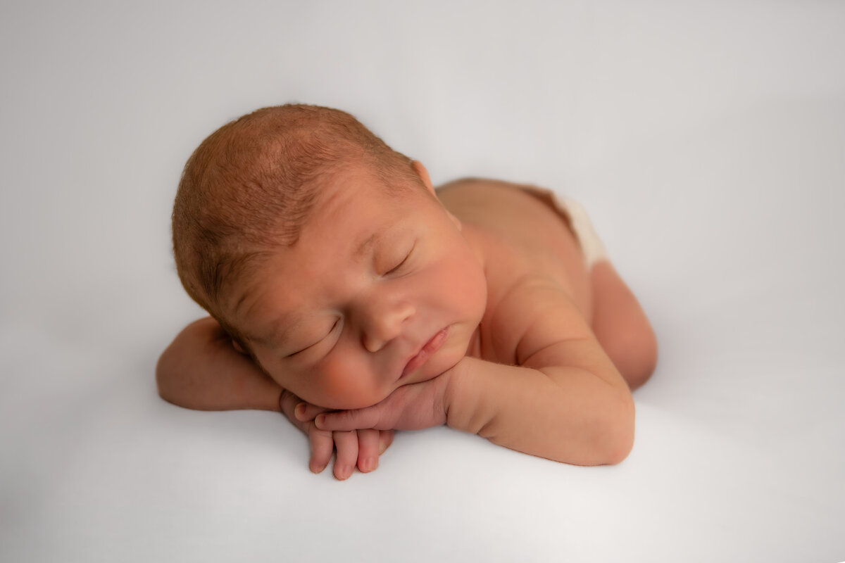 newborn baby boy sleeping on white background
